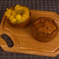 Game pie served with bowl of piccalilli